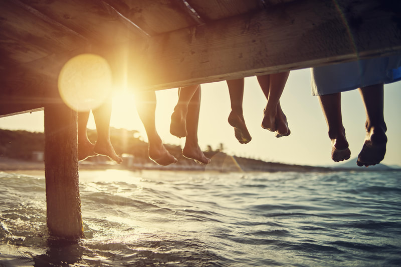 feet dangling off of pier 